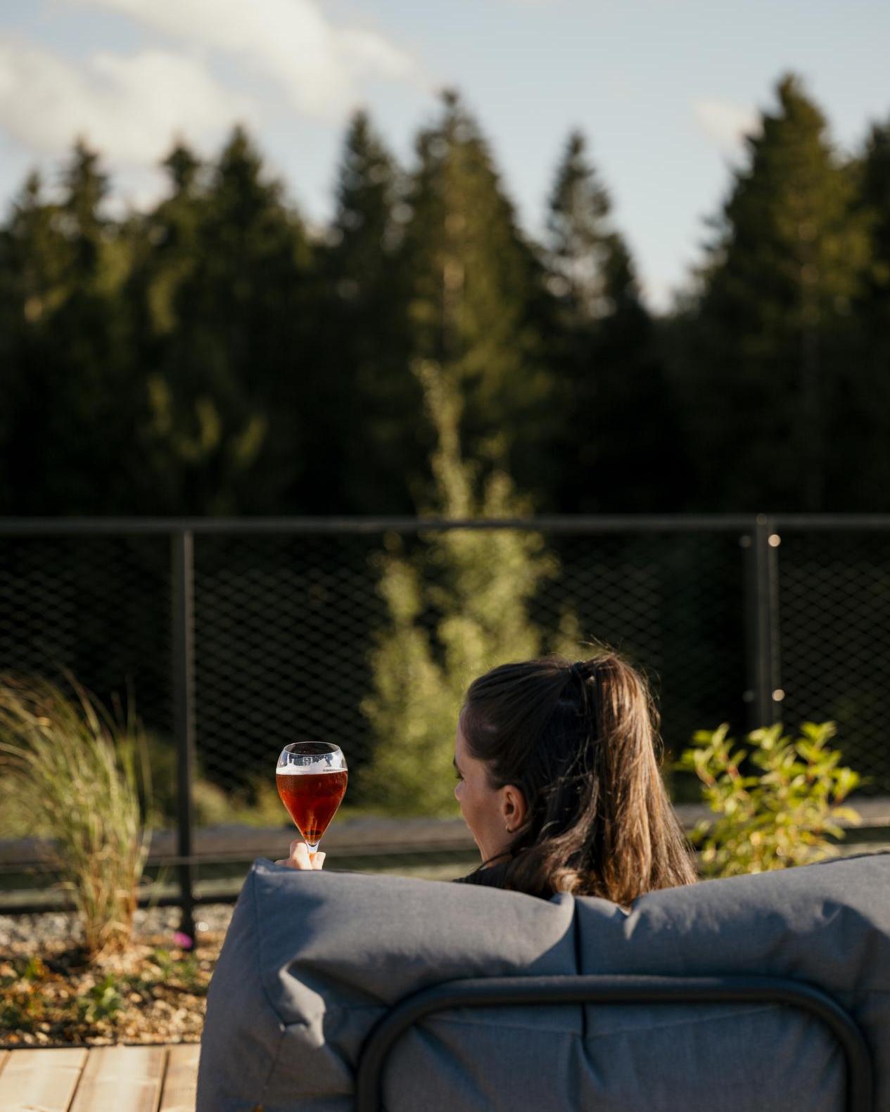 Frau-mit-Weingals-Dachterrasse-Wellnessgarten-KraftquelleFANNY-Wellnesshotel-Allgaeu