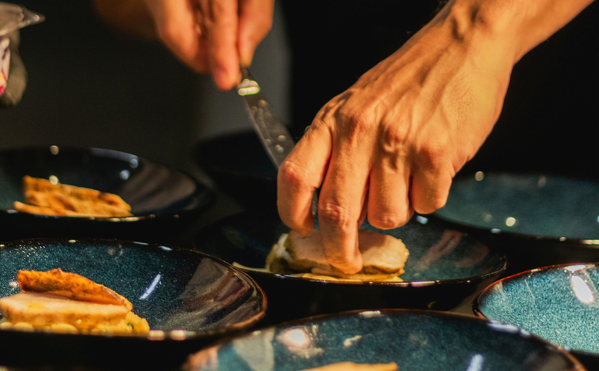 Koch richtet ein Gericht auf Tellern an