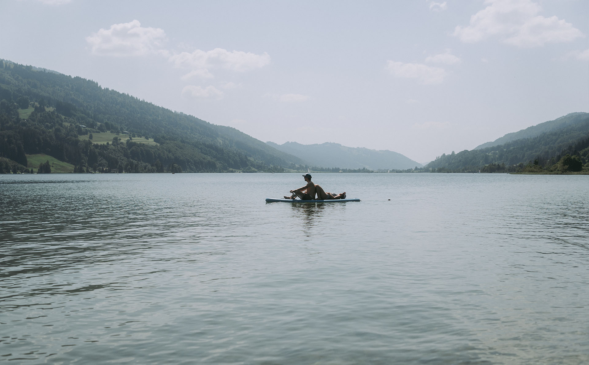 Person beim Stand Up Paddling auf dem Großen Alpsee im Allgäu