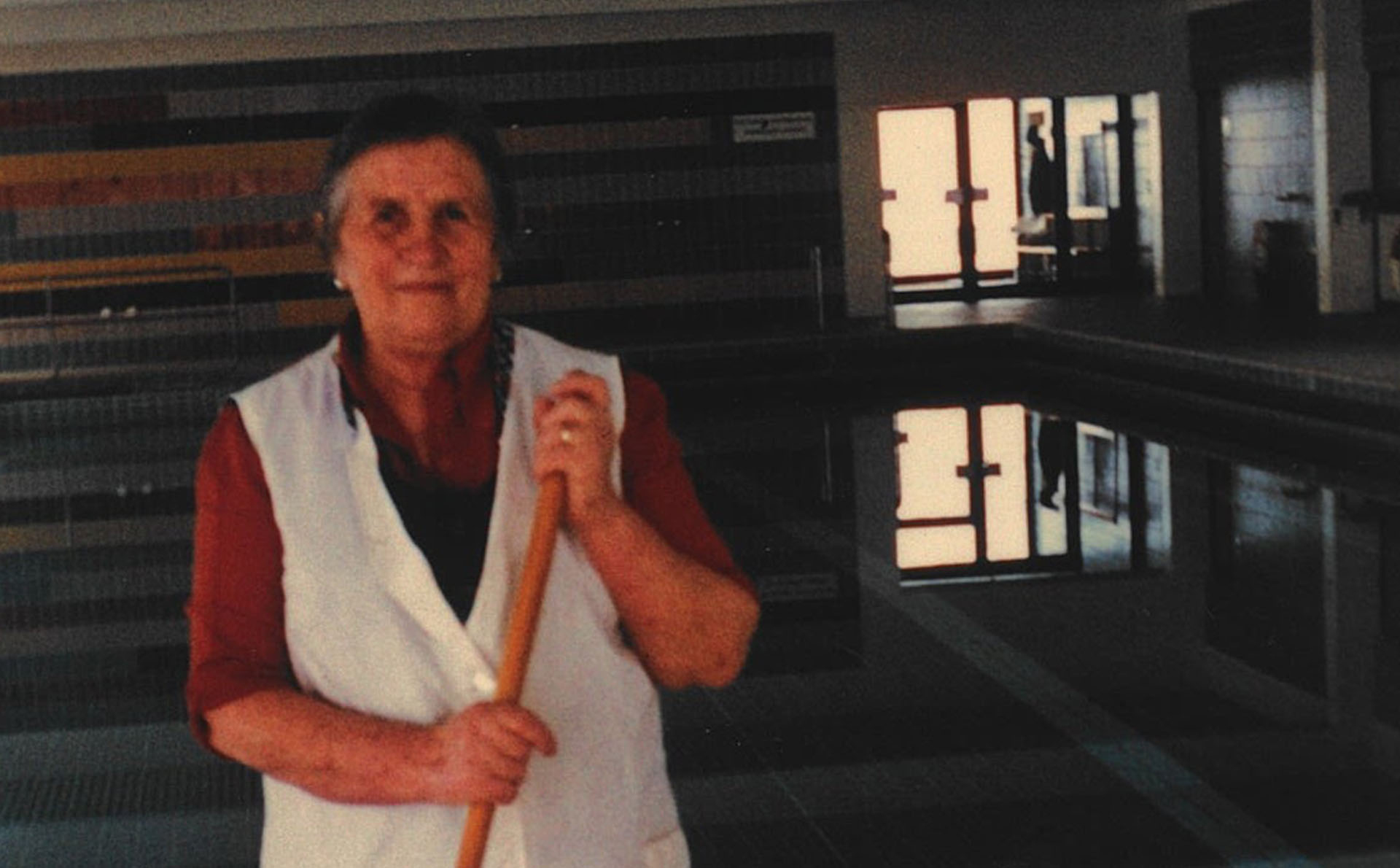 Fanny Übelhör als Bademeisterin mit Besen im Hallenbad