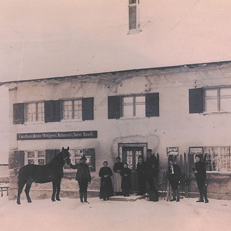Historisches Gasthaus mit Menschen und Pferd vor dem Gebäude