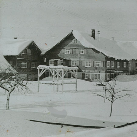 Historisches Gasthaus im Winter mit tief verschneiter Landschaft