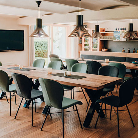 Moderner Gastraum mit Holztisch und Stühlen im Hotel