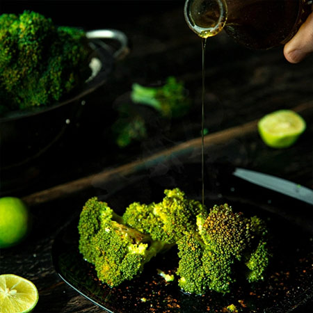 Brokkoli wird mit Öl und Gewürzen verfeinert