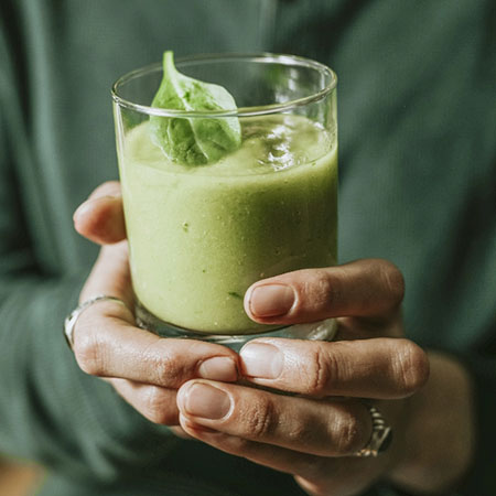 Grüner Smoothie im Glas mit frischen Zutaten