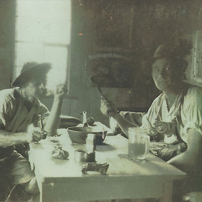 Zwei Männer sitzen am Tisch in einer Stube