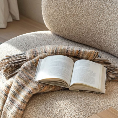 Offenes Buch auf einem gemütlichen Sessel
