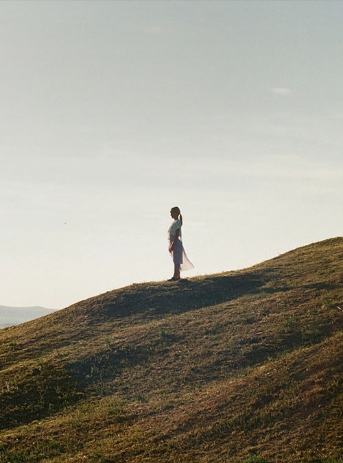 Frau steht auf einem Hügel in der Allgäuer Natur