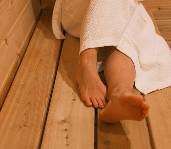 Entspannte Füße auf einer Saunabank