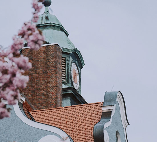 Kirchturm in Kempten mit Kirschblüten im Vordergrund