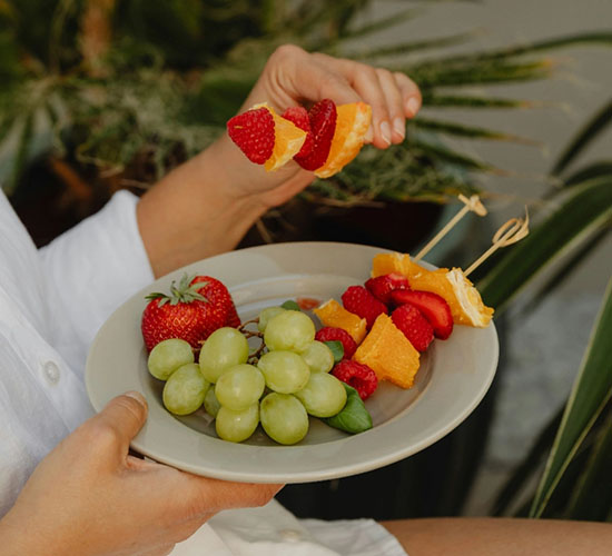 Obstteller mit Trauben, Erdbeeren und Fruchtspießen