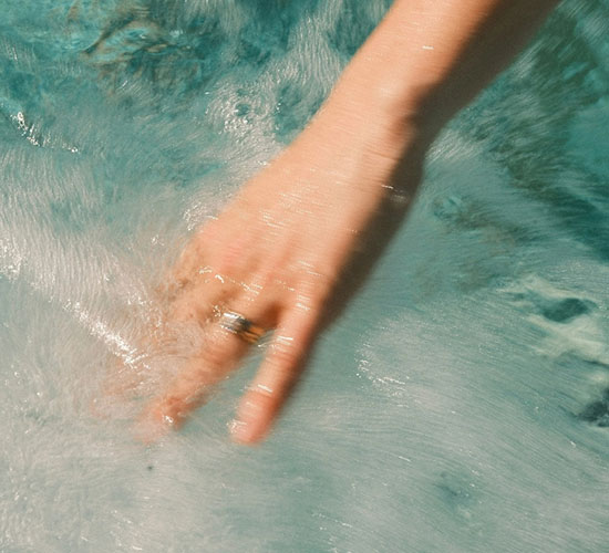 Hand bewegt sich durch sprudelndes Wasser