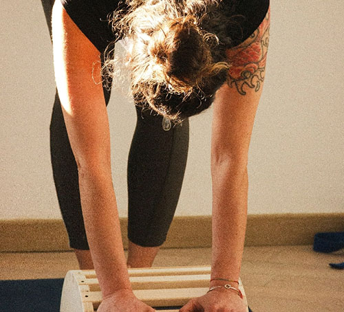 Dehnübung mit Yogahocker im Bewegungsraum