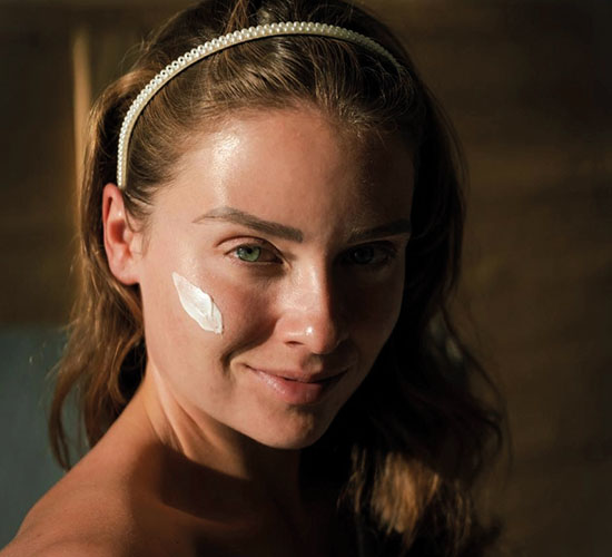 Frau trägt Gesichtscreme auf die Haut auf