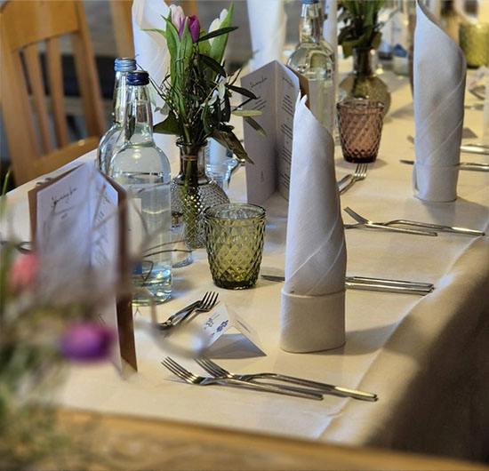 Gedeckter Restauranttisch mit Blumen und Gläsern