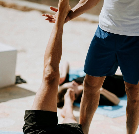 Personal Trainer unterstützt bei einer Dehnübung