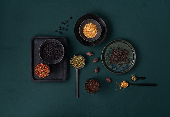 Verschiedene Gewürze und Zutaten stilvoll auf dunklem Hintergrund arrangiert