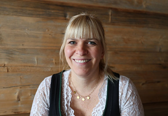 Blonde Mitarbeiterin im Dirndl mit freundlichem Lächeln