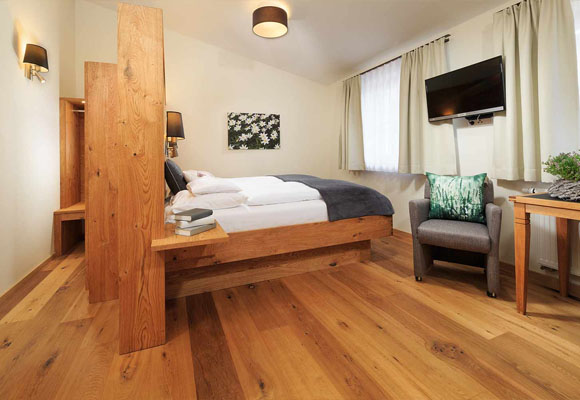 Modernes Doppelzimmer mit großem Bett und offener Raumgestaltung