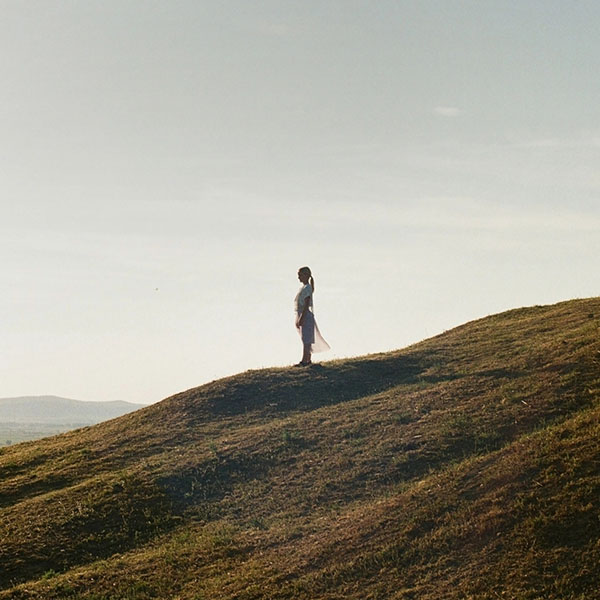 Frau steht auf einem Hügel und blickt über die Allgäuer Landschaft