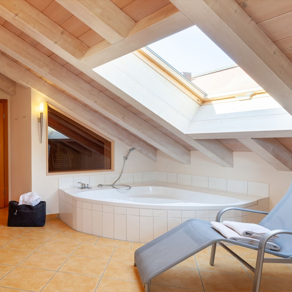 Gemütliches Schlafzimmer mit Dachbalken, Holzbett und Blick aus dem Fenster