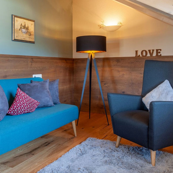 Gemütliche Sitzecke mit Sofa, Sessel und Stehlampe