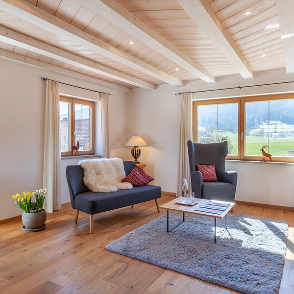 Heller Wohnbereich mit Sofa, Sesseln und großem Fenste