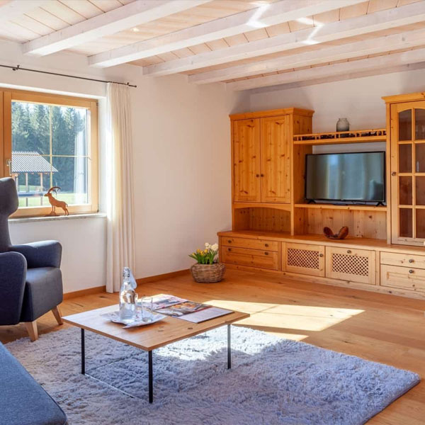 Wohnzimmer mit Sofa, Fernseher und Holzmöbeln