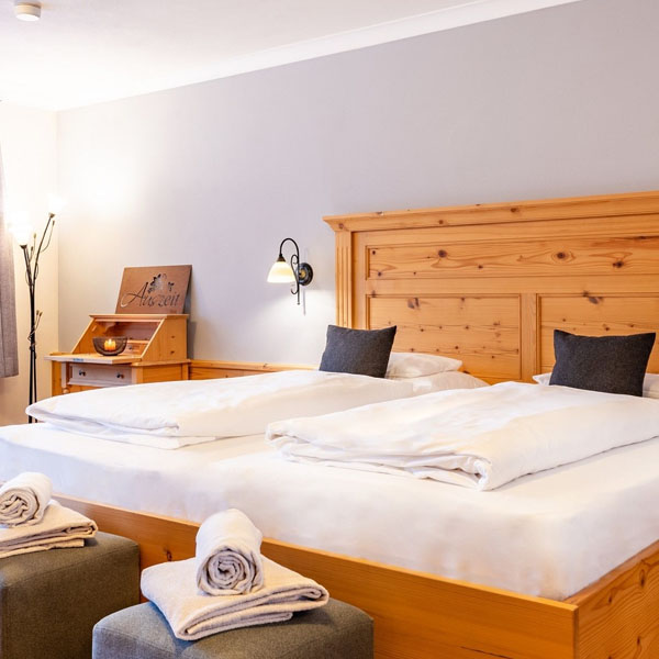 Doppelbett mit Holzrahmen und Nachtlampe