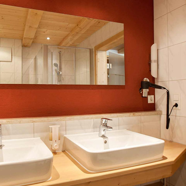 Badezimmer mit Waschbecken, Spiegel und Dusche