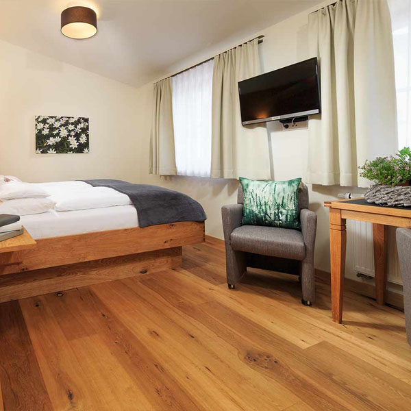 Doppelzimmer mit Bett und hellem Raumdesign