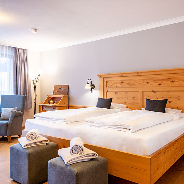 Familienzimmer mit Holzbett und Sitzmöbeln