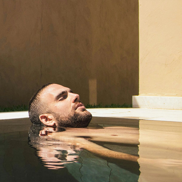 Mann lehnt entspannt im Spa-Pool mit geschlossenen Augen
