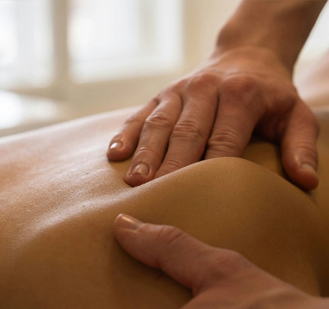 Hände massieren den Rücken einer Person