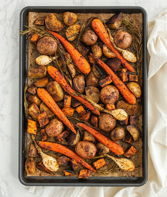 Ofengemüse mit Karotten, Kartoffeln und Kräutern auf einem Backblech