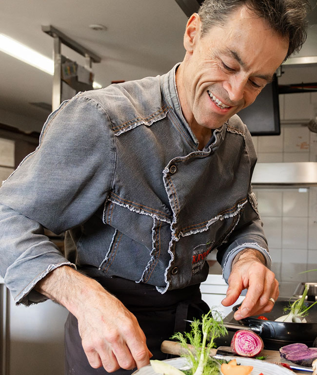 Gastgeber Frank bereitet in der Küche frische Zutaten zu