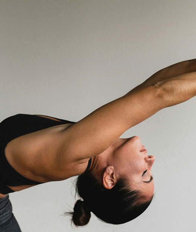 Frau macht eine Yoga-Übung im Seitenprofil mit ausgestreckten Armen