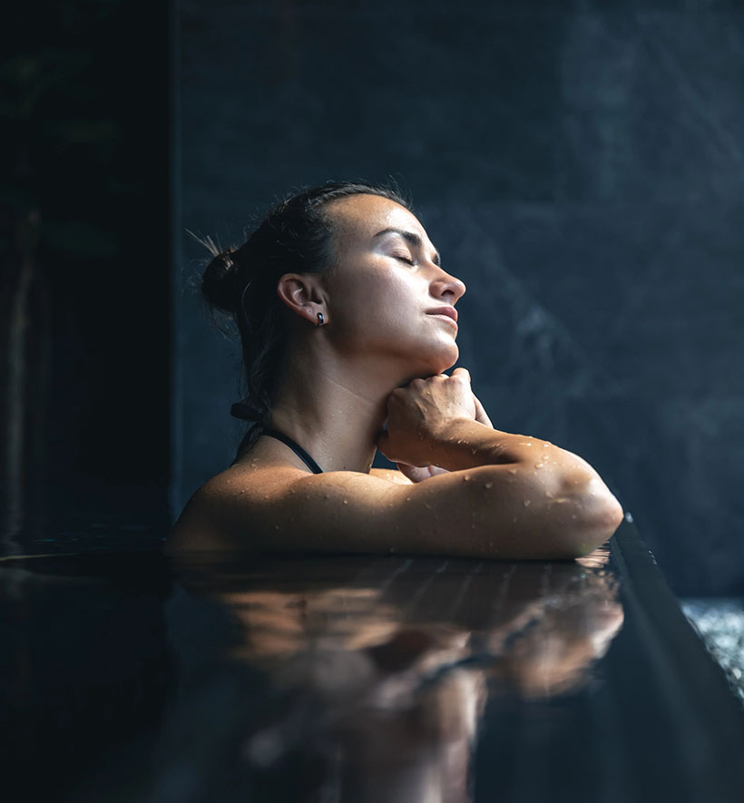 Frau lehnt entspannt im Spa-Pool und genießt die ruhige Atmosphäre