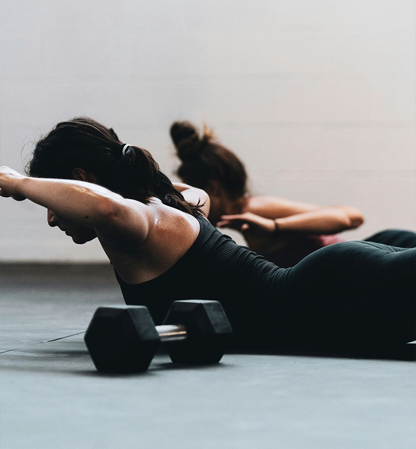Frauen machen Krafttraining mit Hanteln im Fitnessstudio