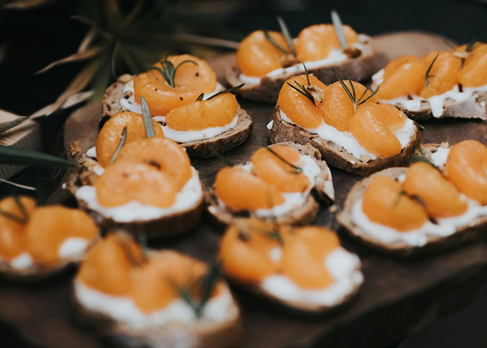 Fingerfood-Häppchen mit Frischkäse und Früchten auf Brot