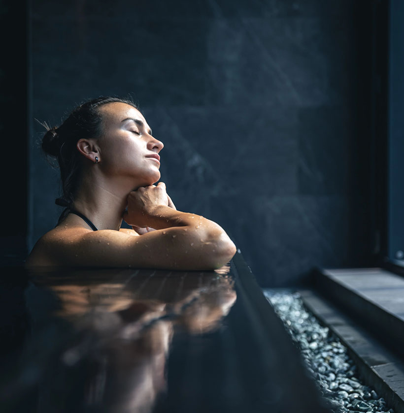Frau entspannt im warmen Spa-Pool im Wellnessbereich